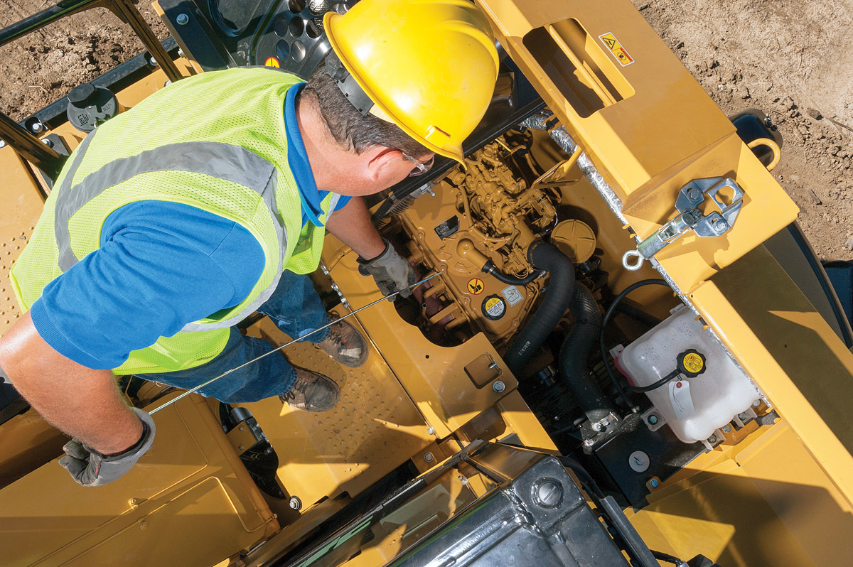 A contractor performs engine maintenance on a Caterpillar excavator. The oil and grease checks should be completed on a regular routine.